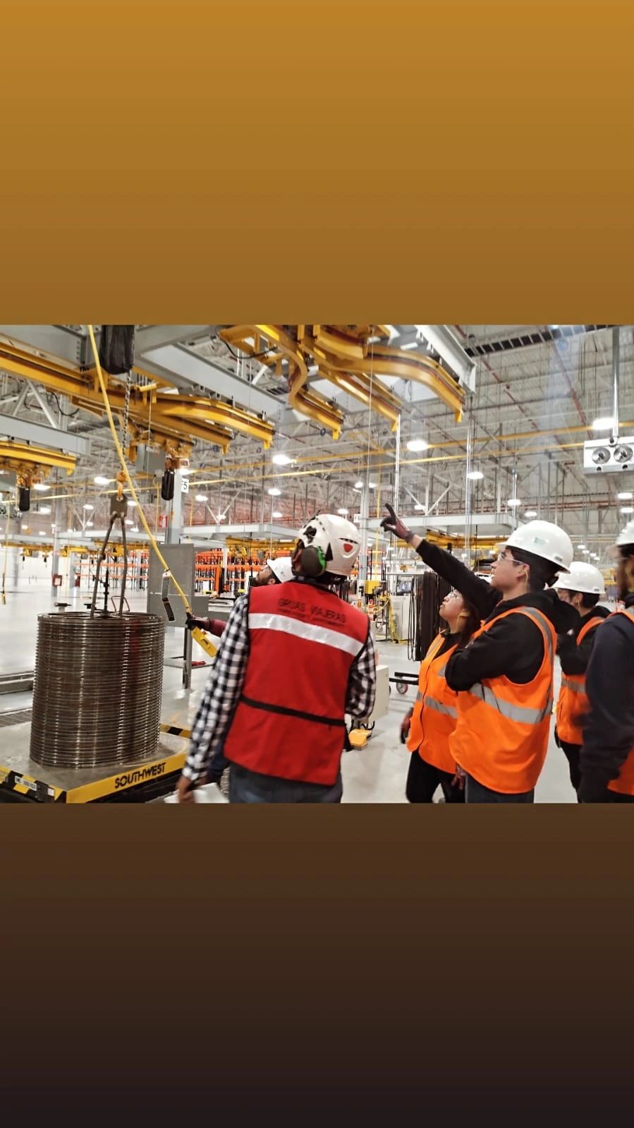 Trabajadores con chalecos naranja en almacén industrial